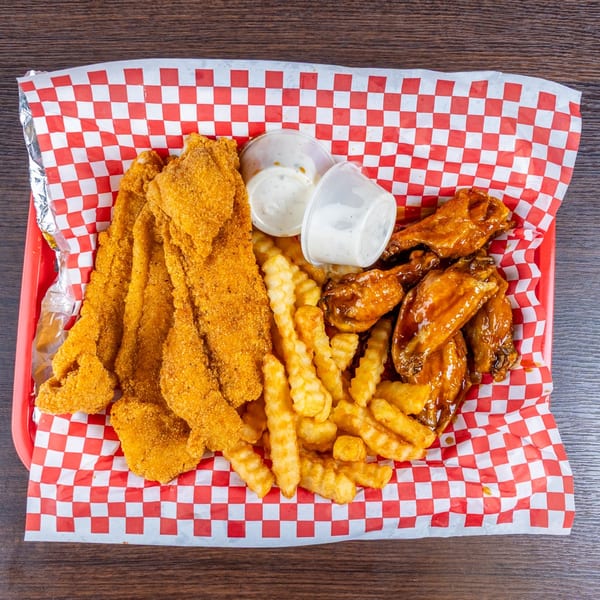 Basket of breaded fish, crinkle-cut fries, sauced chicken wings, and dipping sauces on red-and-white checkered paper.